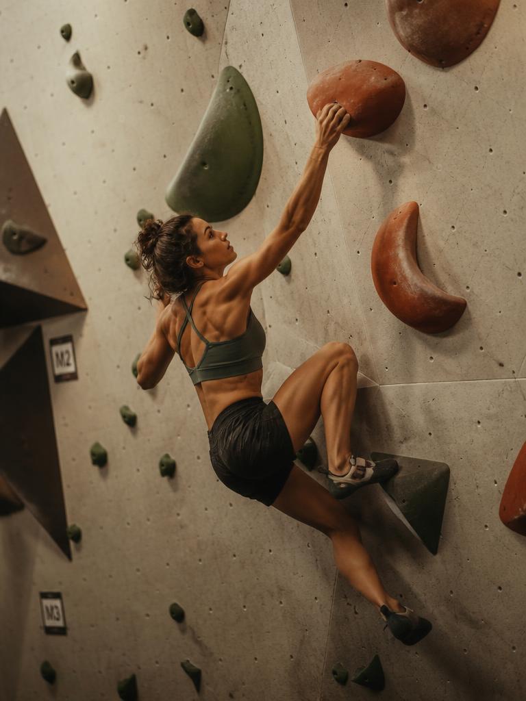 Persona escalando un muro indoor con arnés